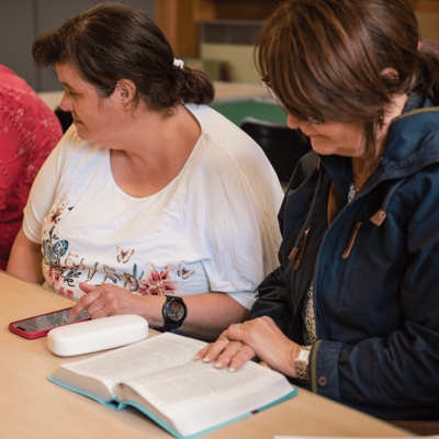 Ladies gathered around a table with open bibles