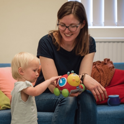 A woman supervising a child playing